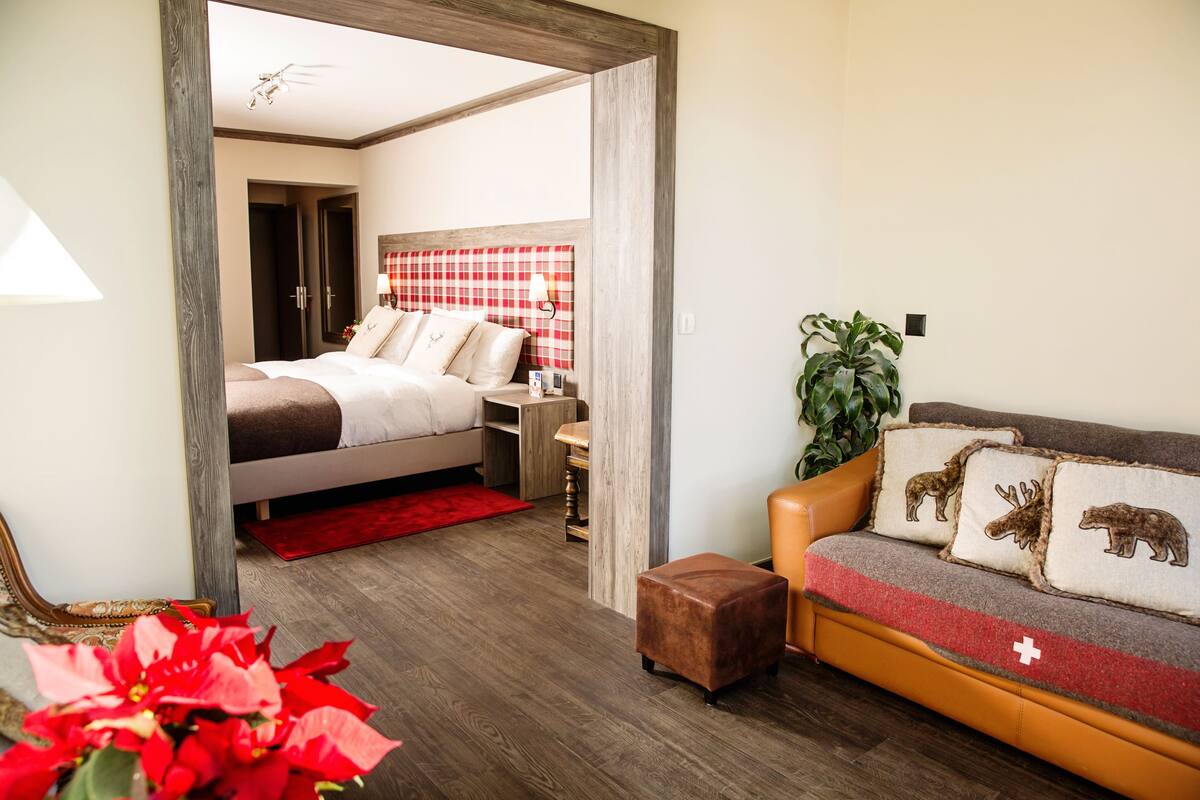 A modern bedroom with a bed, bedside table, and a red plaid headboard.