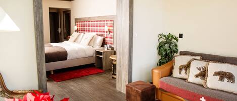 A modern bedroom with a bed, bedside table, and a red plaid headboard.
