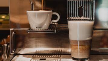 A coffee machine with a cup and a glass of coffee.