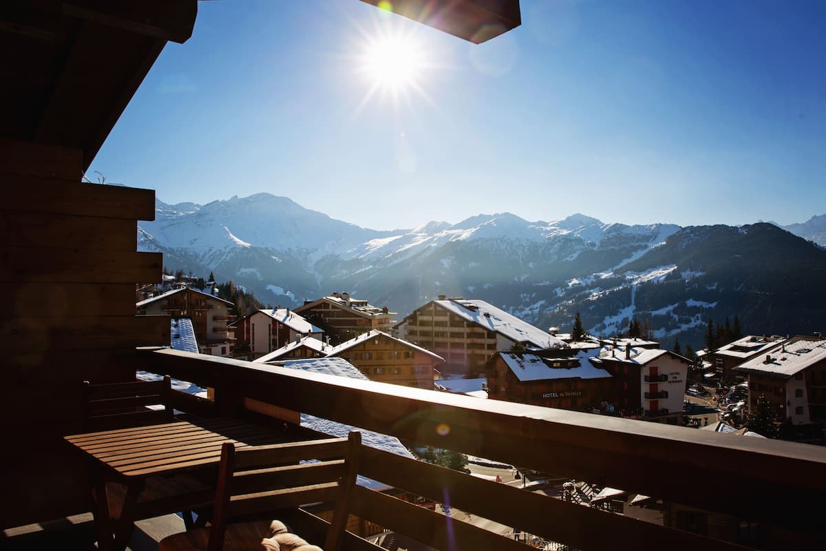 A mountain town with snow-covered buildings and a clear view of snow-capped mountains.