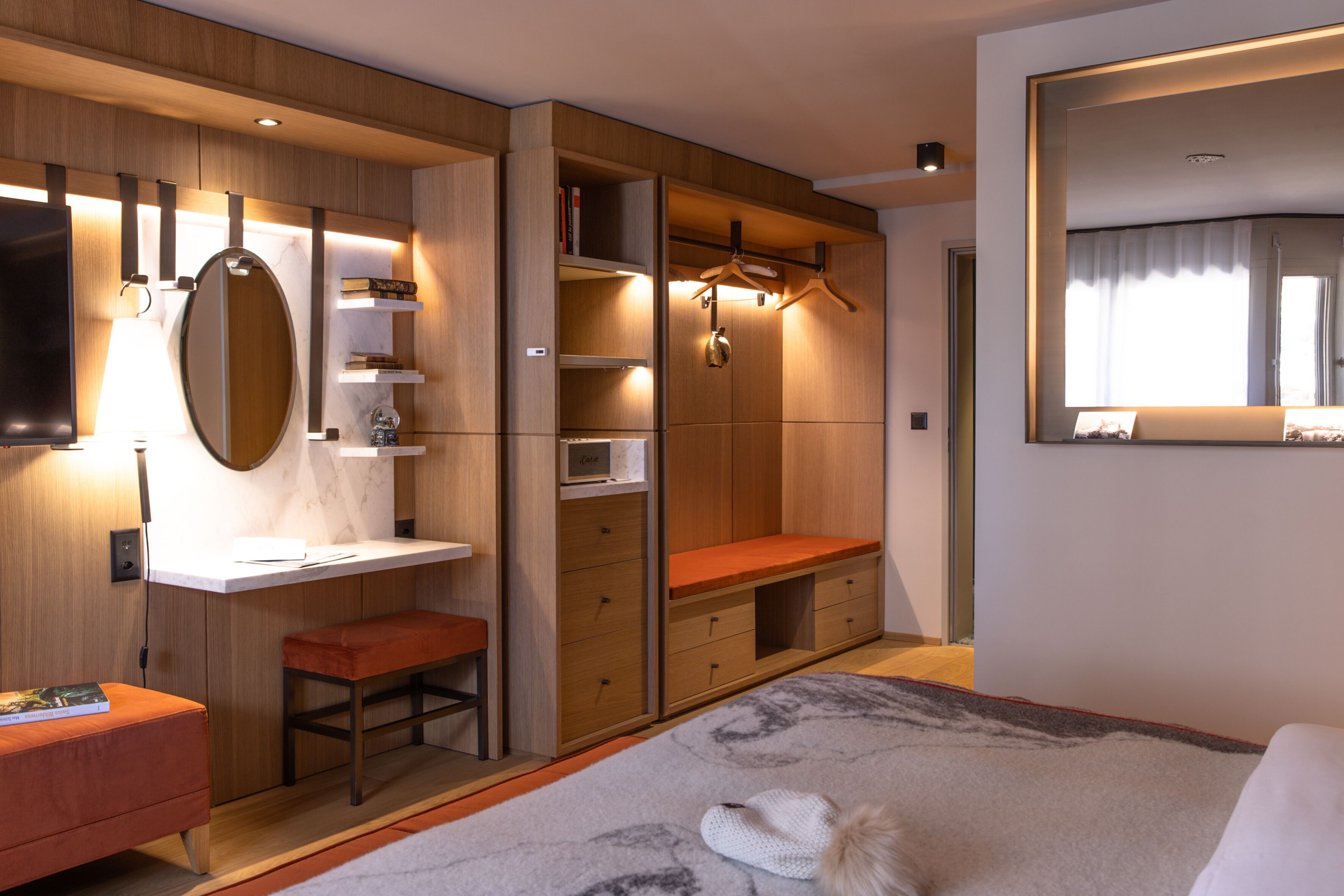 Een moderne slaapkamer met een groot bed, een inbouwkast, een spiegel en een garderobe.