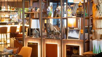 A cozy bar area with wooden shelves displaying various decorative items, including vases and sculptures.