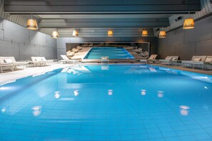 Una piscina cubierta, tumbonas