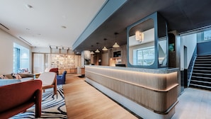 A modern hotel lobby with a reception desk, seating area, and a staircase. - Sorell Boutique-Hotel Seefeld Zürich (Zürich)