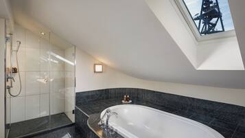 Ein modernes Badezimmer mit freistehender Badewanne, einer Glasdusche und einem Oberlicht.