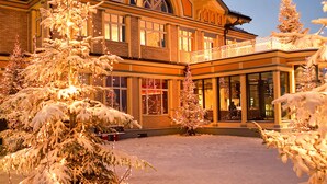 A large, multi-story building with a prominent arched window and a balcony with lights. - Hotel UTO KULM car-free hideaway in Zurich (Zürich)