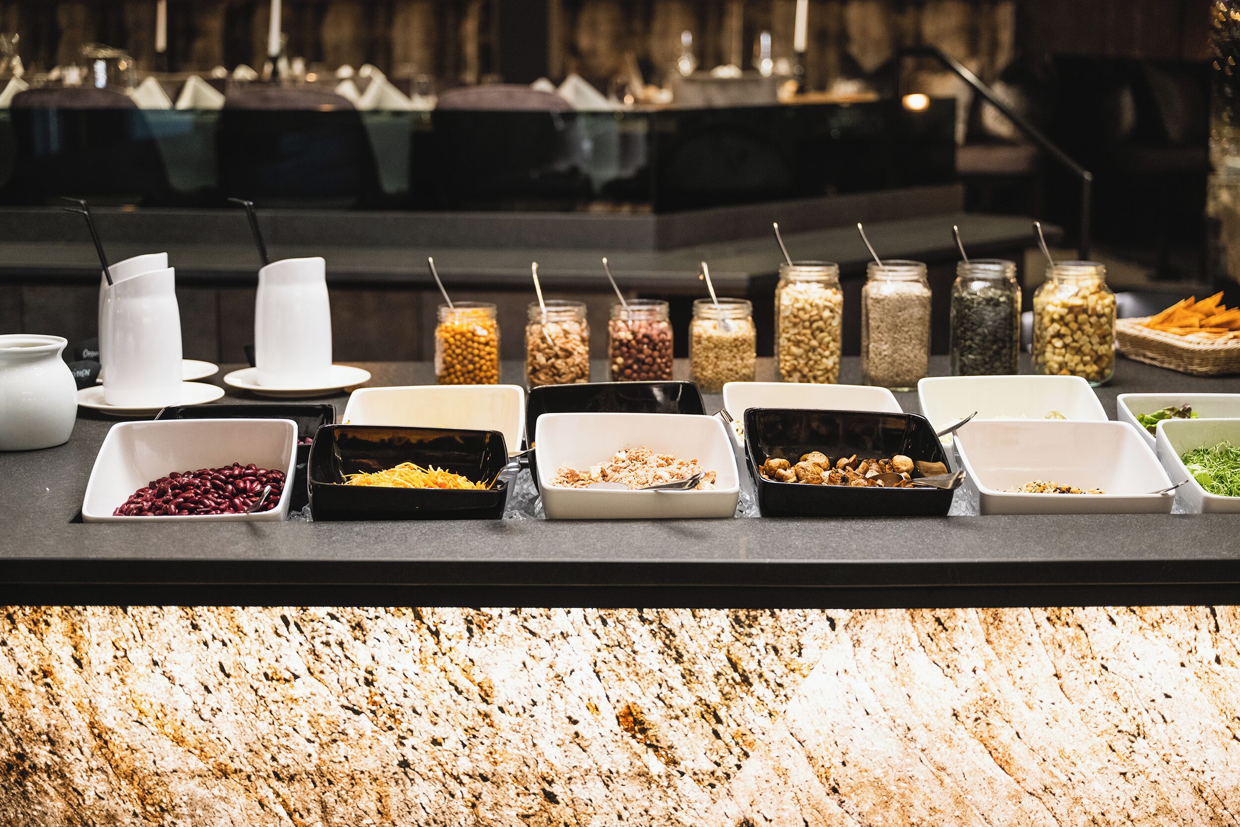 Mostrador de buffet con diversos alimentos y recipientes.
