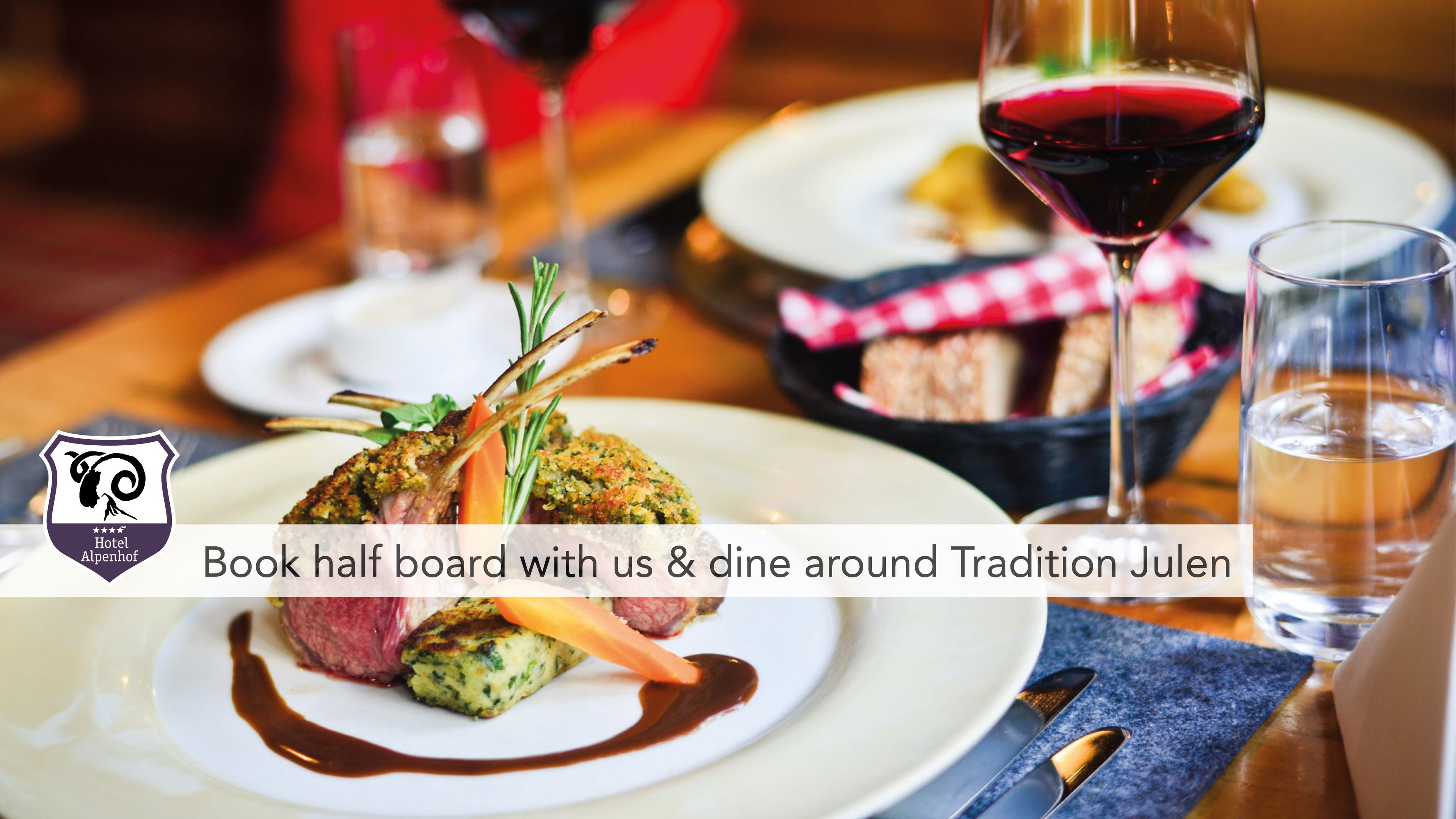 A dining table with a variety of dishes, including a lamb shank, a vegetable tart, and a dessert. There are glasses of red wine and water on the table.