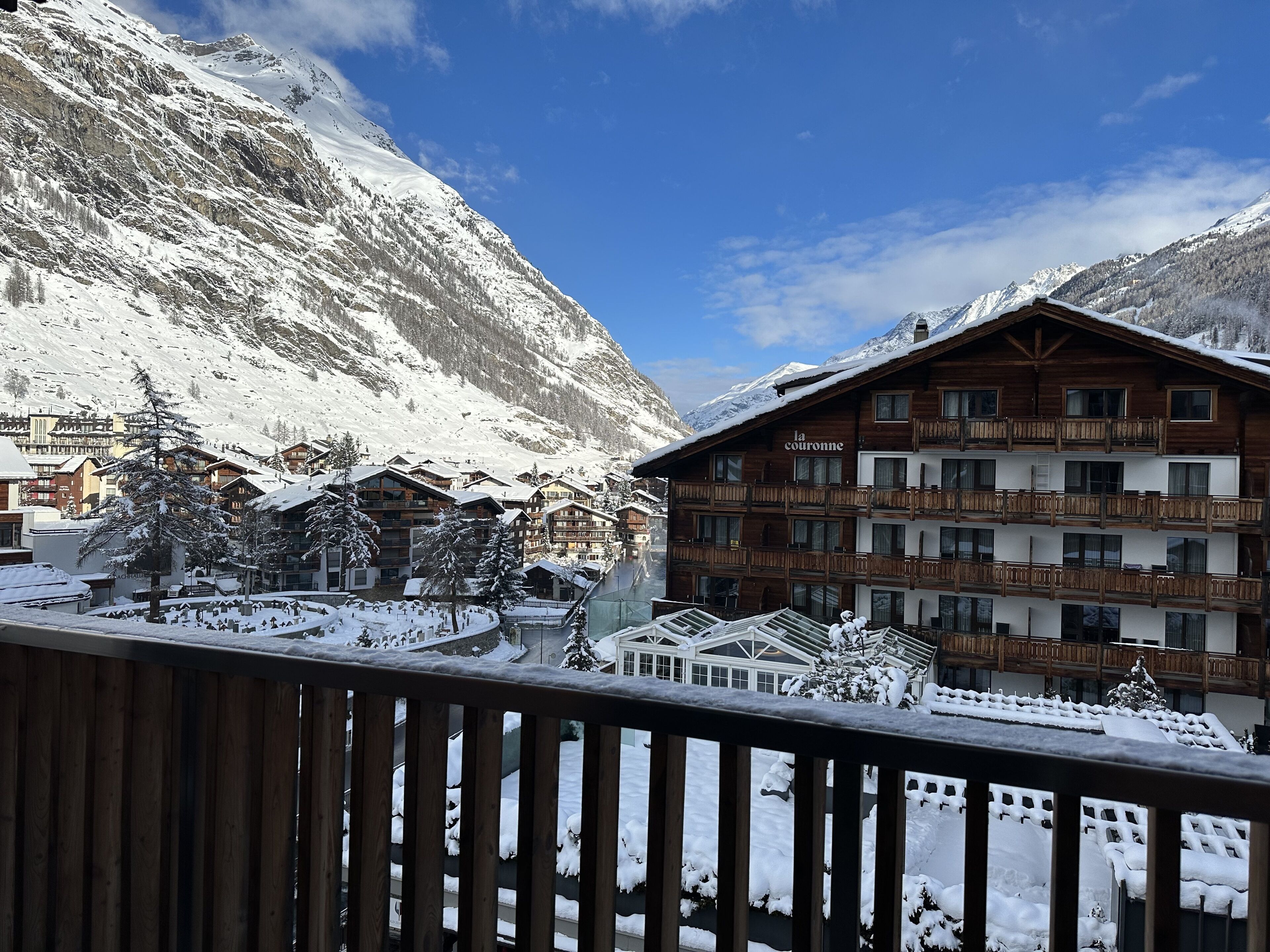 A snow-covered mountain village with wooden buildings and a chalet named "la couronne".