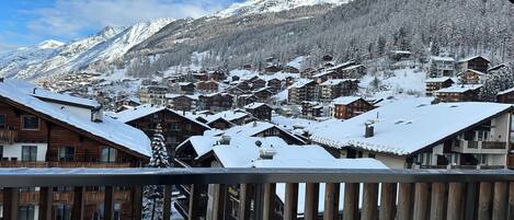 A snow-covered mountain town with wooden buildings and a clear sky.