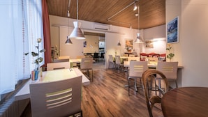 A modern dining area with wooden flooring, contemporary furniture, and pendant lighting. - Hotel Derby Interlaken - Action & Relax Hub (Interlaken)