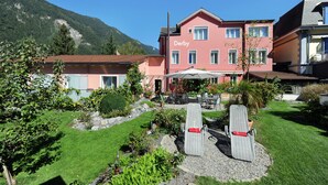 A hotel named 'Derby' with a garden area featuring a pool, outdoor seating, and a view of a mountain. - Hotel Derby Interlaken - Action & Relax Hub (Interlaken)
