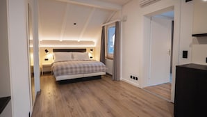 A modern bedroom with a large bed, bedside lamps, a window with curtains, and a wooden floor. - Hotel Derby Interlaken - Action & Relax Hub (Interlaken)