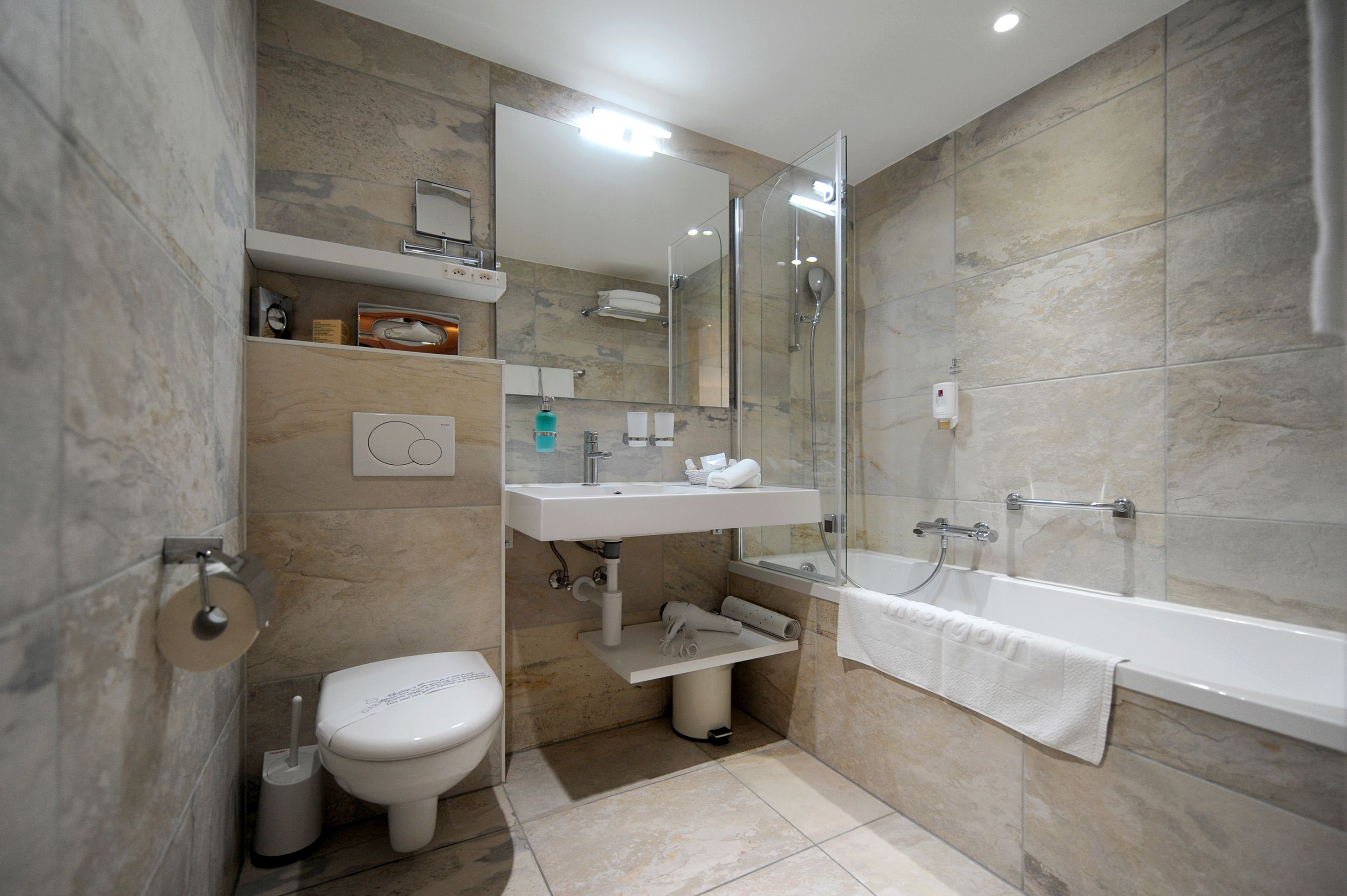 Une salle de bain moderne équipée de toilettes, d’un lavabo et d’une baignoire.