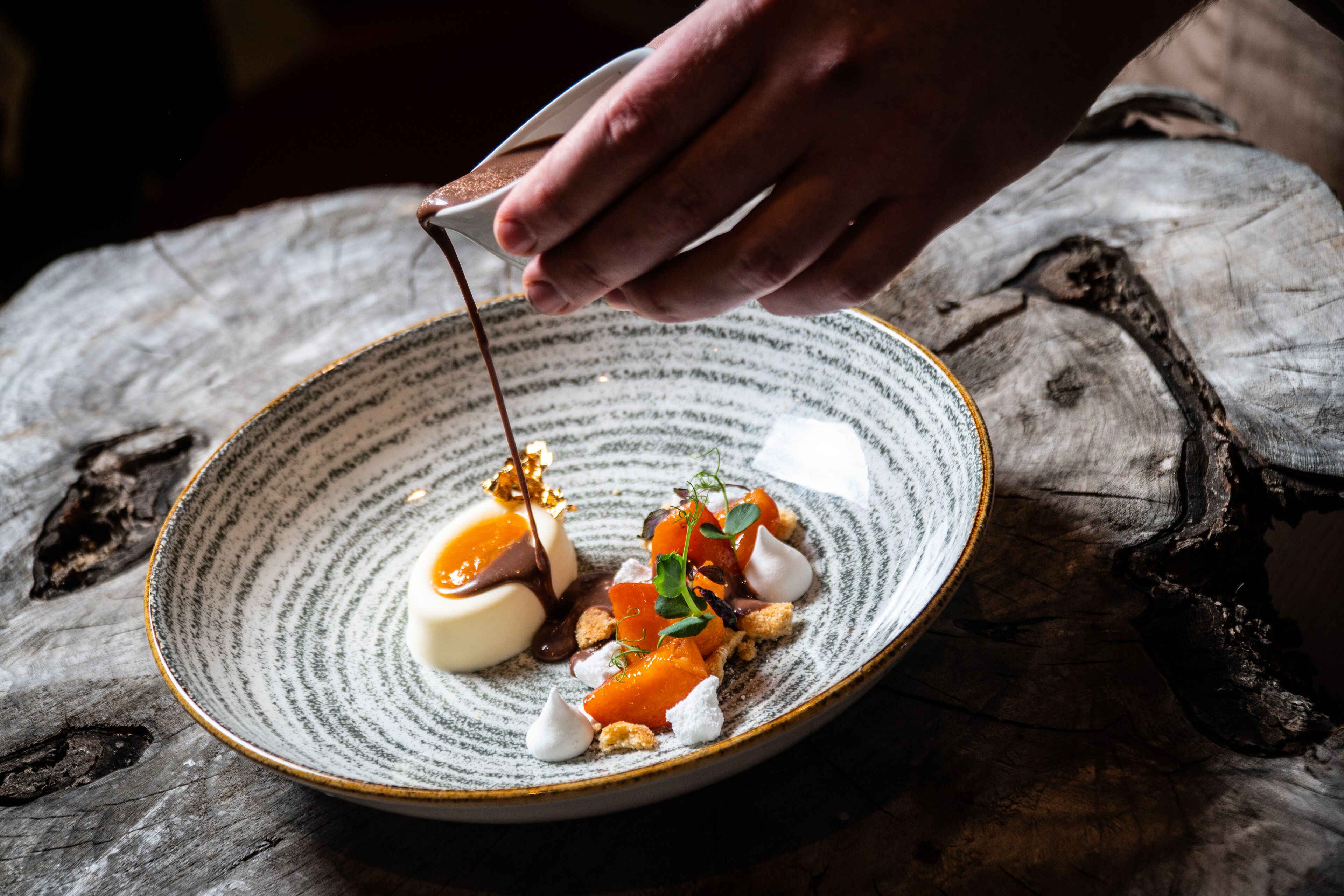 Un dessert présenté sur une assiette en céramique, avec un décor de fond en bois rustique.