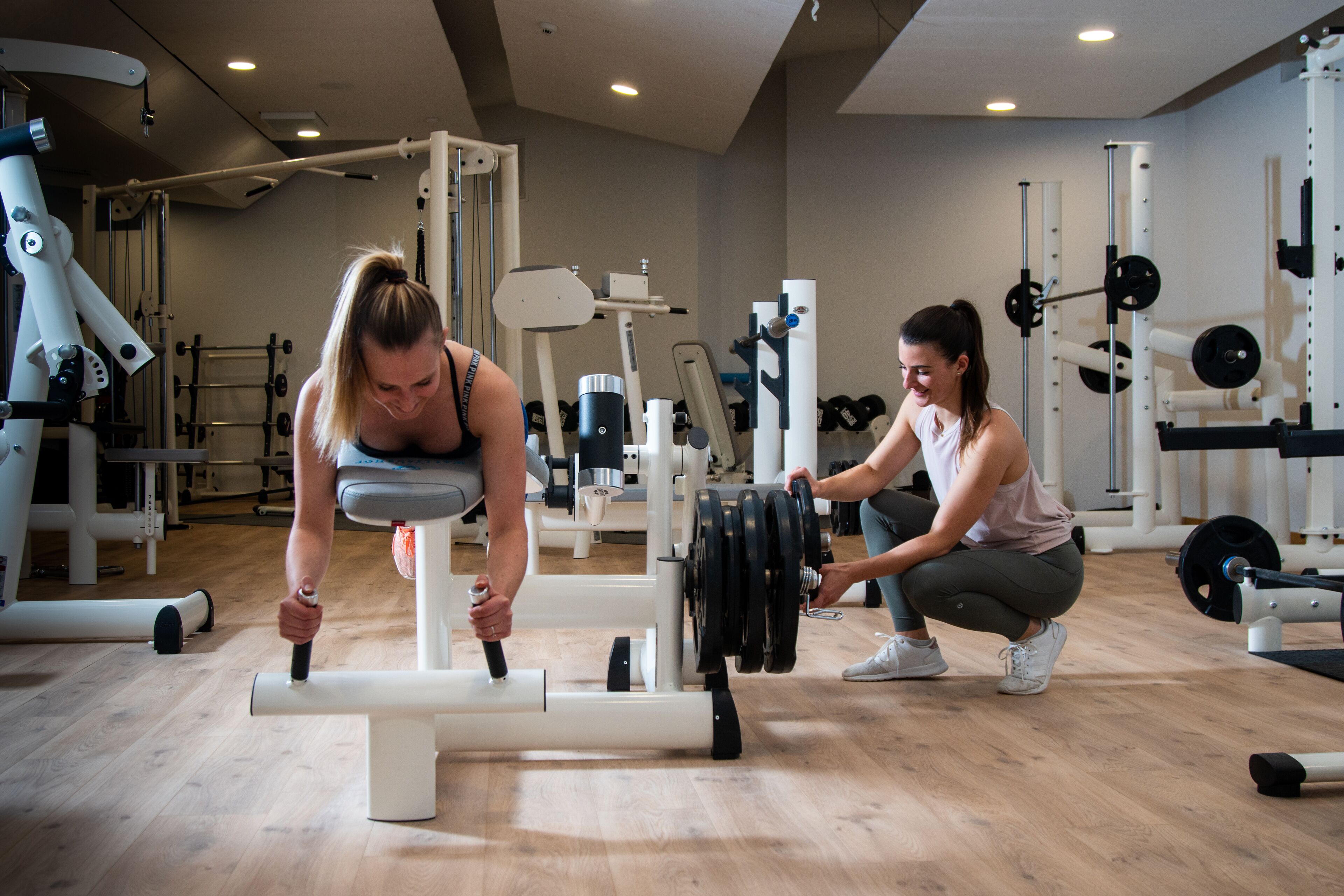 A gym with various exercise equipment, including a bench press and weight racks.