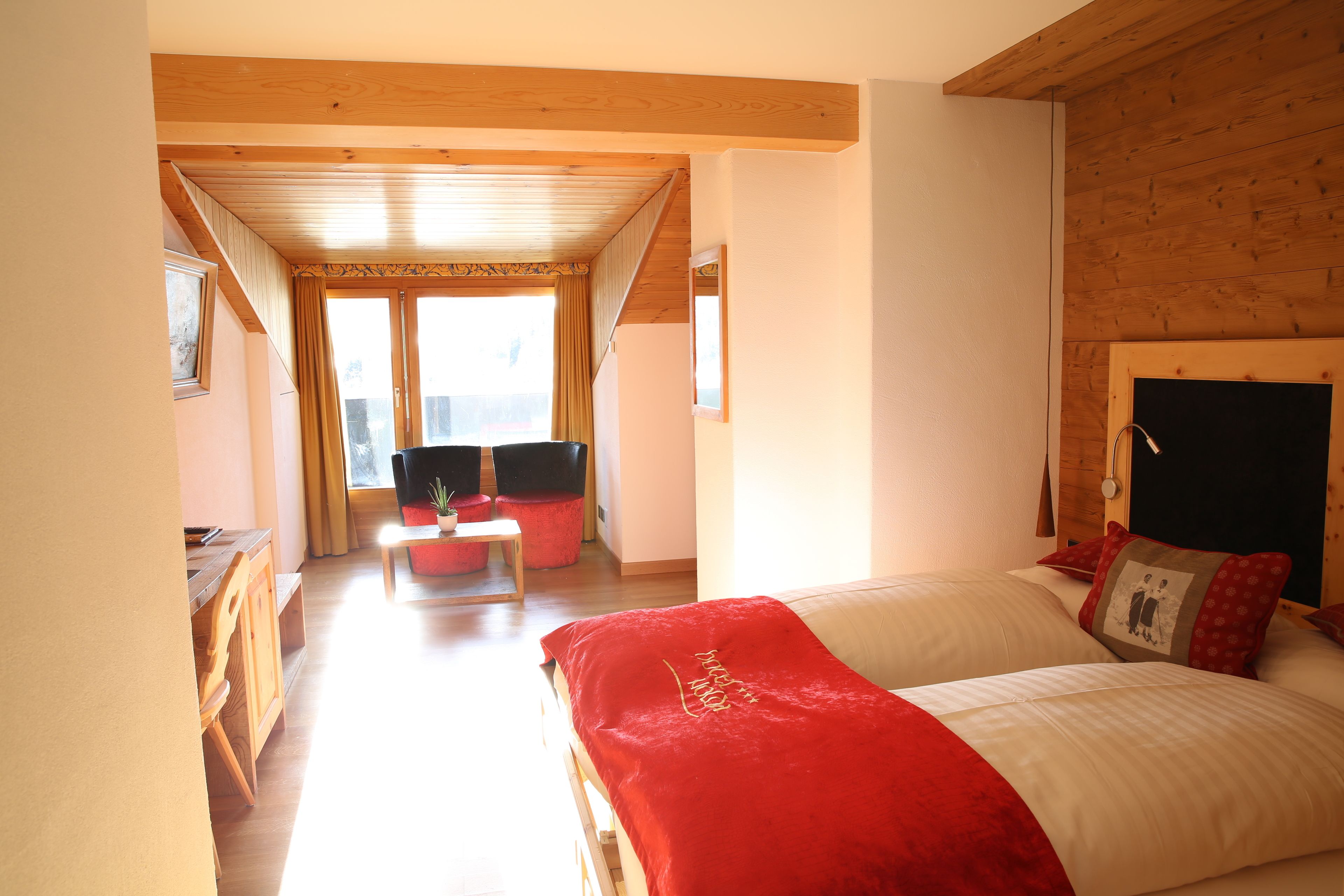 Un dormitorio con una cama grande, techo de madera y vistas al exterior.