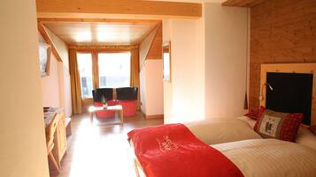 Un dormitorio con una cama grande, techo de madera y vistas al exterior.