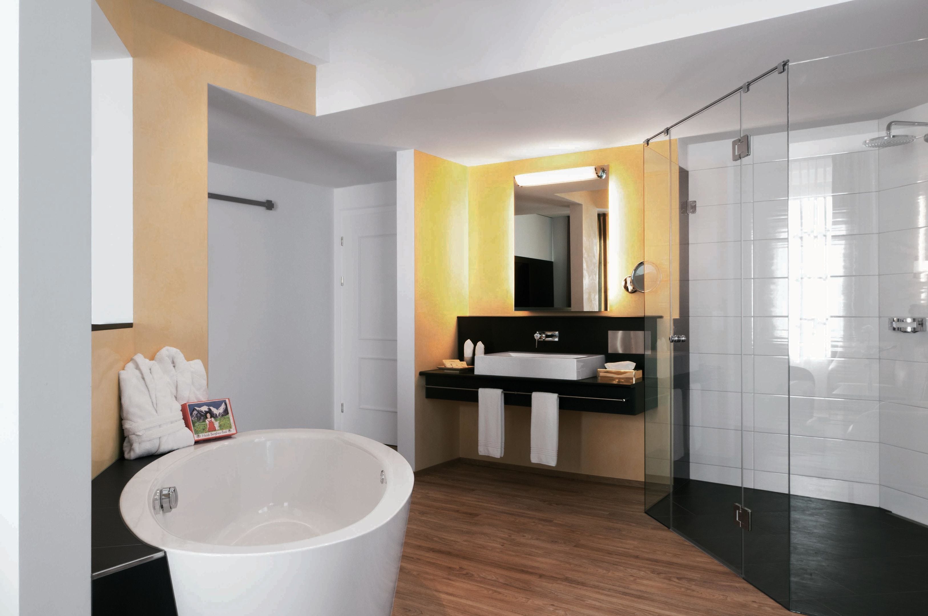 Ein modernes Badezimmer mit einer freistehenden Badewanne, einer gläsernen Dusche und einem Waschtisch mit Spiegel.