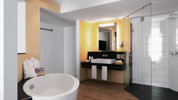 Ein modernes Badezimmer mit einer freistehenden Badewanne, einer gläsernen Dusche und einem Waschtisch mit Spiegel.