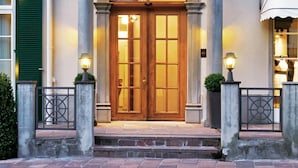 A grand entrance with a wooden door, columns, and a balcony.
