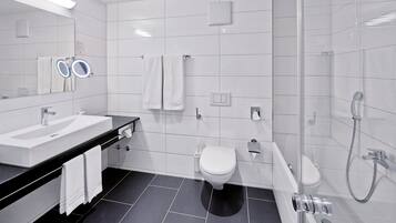 Een moderne badkamer met een wastafel, spiegel, handdoekrek, toilet en douche.