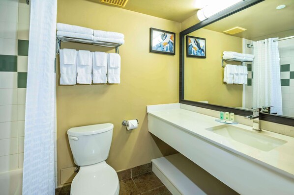 Un baño con inodoro, lavamanos y toallero.