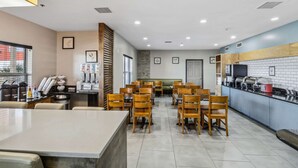 A modern restaurant with wooden chairs, a long counter, and a buffet area.