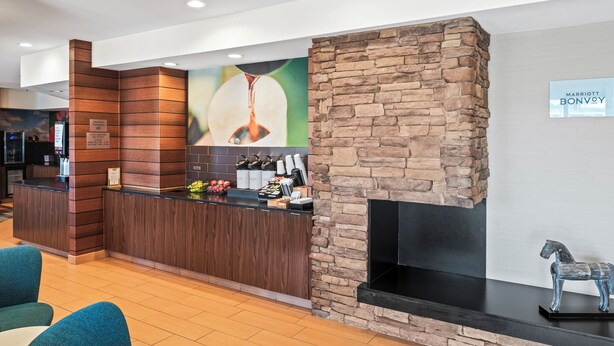 A reception area with a stone fireplace, a counter with amenities, and a sign for Marriott Bonvoy. - Fairfield Inn & Suites by Marriott Columbus (Columbus)