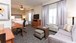 A hotel room with a bed, desk, chair, television, sofa, and a small table. - Homewood Suites by Hilton Indianapolis-Airport/Plainfield (Plainfield)