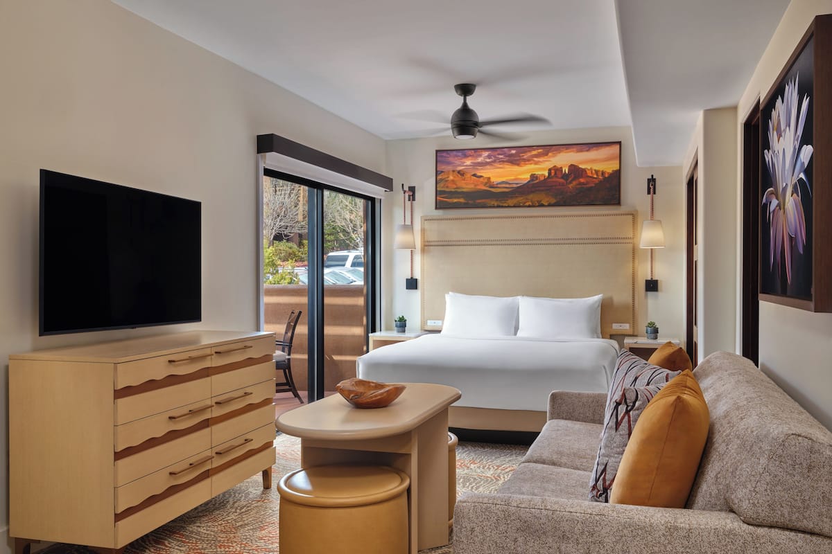 Een hotelkamer met een bed, een televisie, een bureau en een bank.