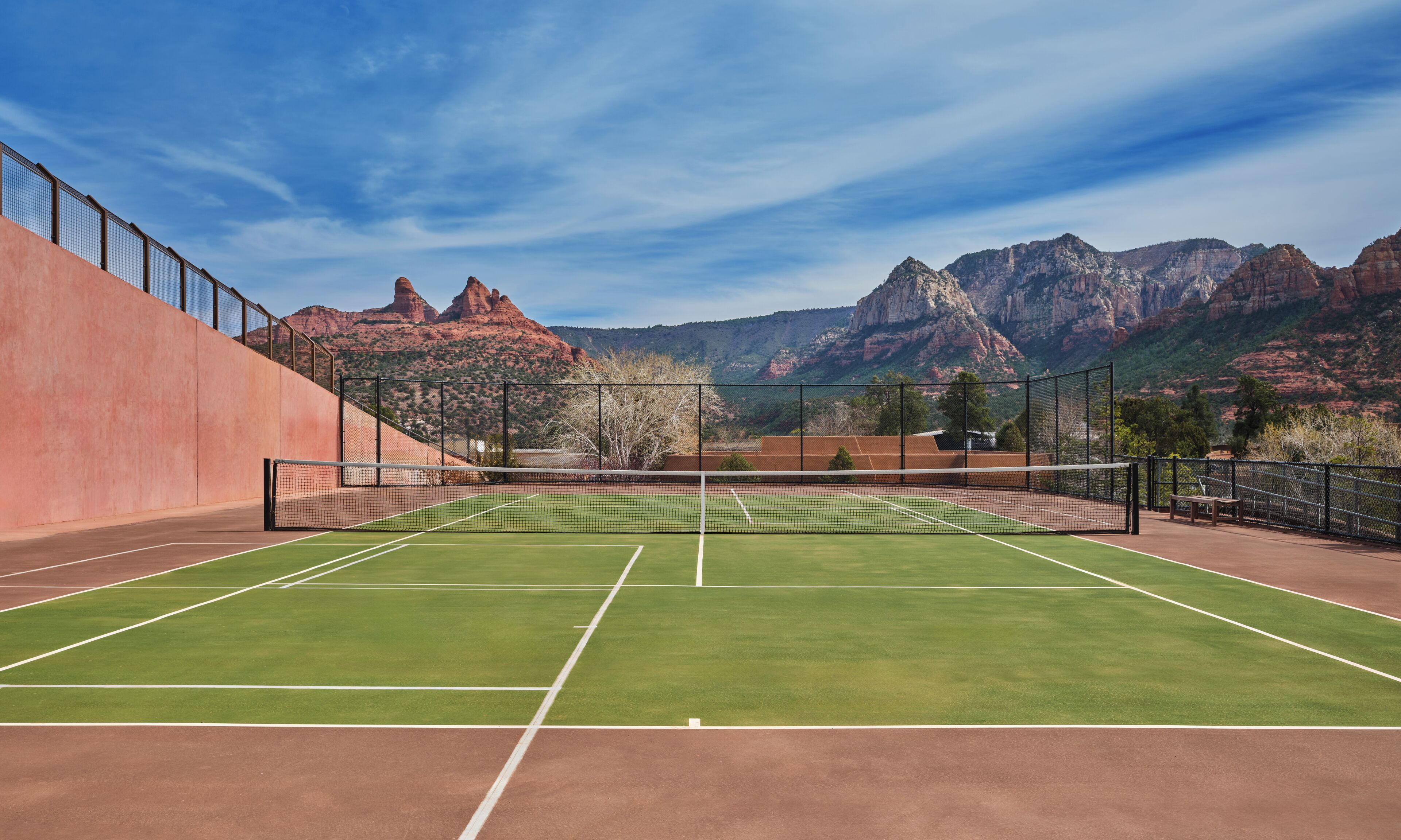 A tennis court with a mountain backdrop.