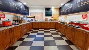 Une cuisine avec un carrelage à motifs, des placards en bois et divers appareils électroménagers.