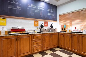 A kitchen with wooden cabinets, a chalkboard with baking instructions, and various kitchen appliances.