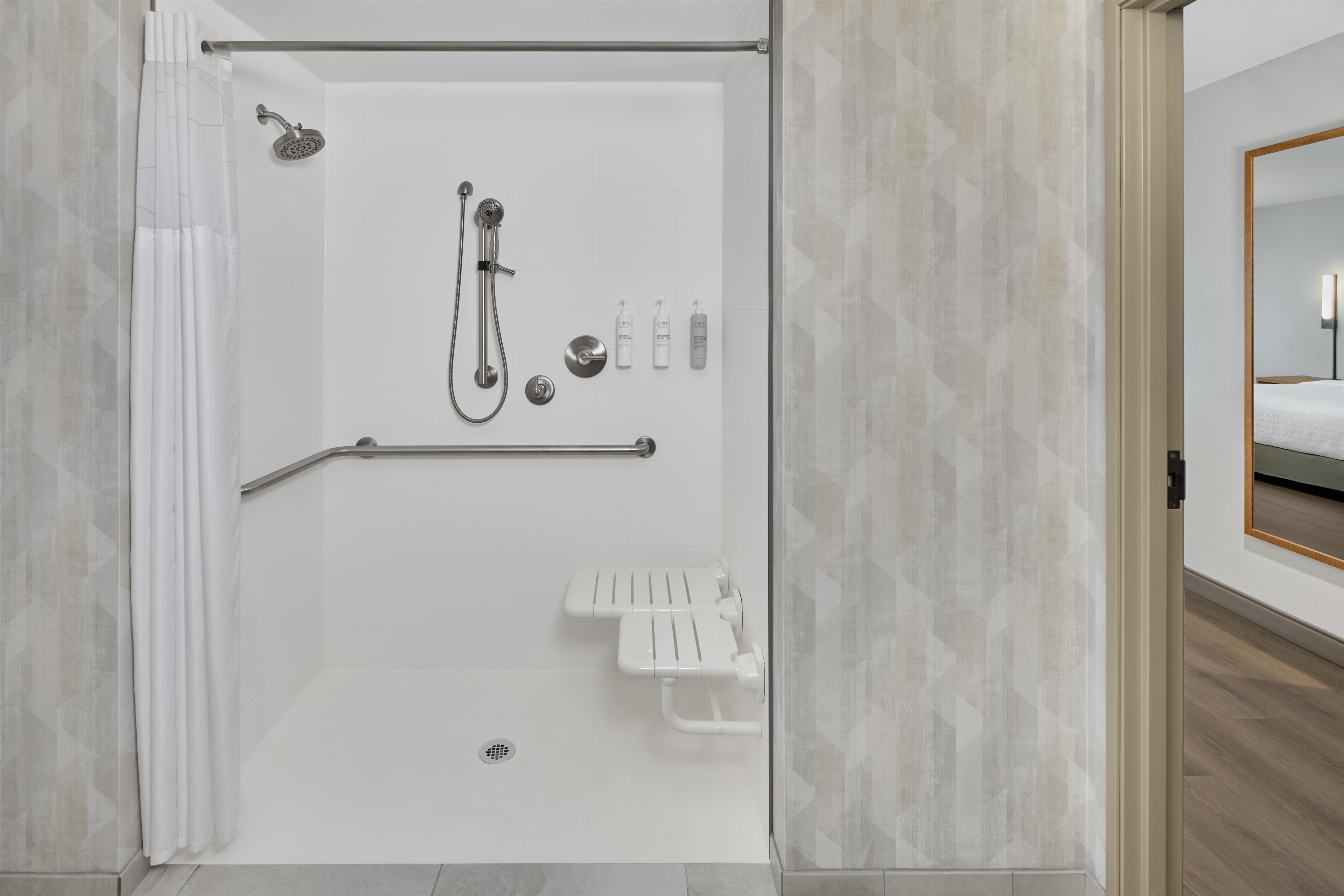 A modern shower with a handheld showerhead, a handheld shower attachment, and a handheld scrubber.