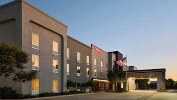 A modern hotel building with a flat facade, multiple windows, and a welcoming entrance.