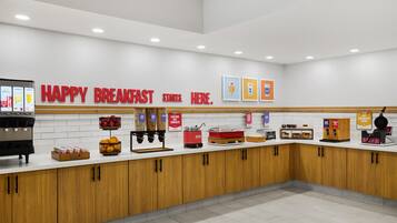 A breakfast area with a counter, coffee machines, and a sign that says 'HAPPY BREAKFAST STARTS HERE.'