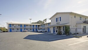 A motel with a two-story structure, a parking lot, and a fenced area. - Americas Best Value Inn Beaumont, CA (Beaumont)