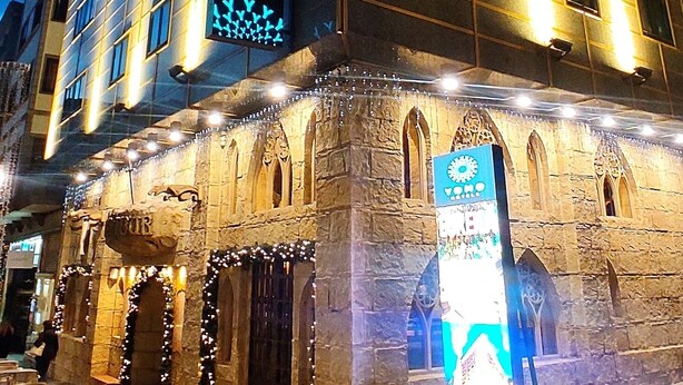 A hotel with a modern facade, a prominent sign, and a stone entrance with decorative lighting. - Yomo Eureka (Escaldes-Engordany)