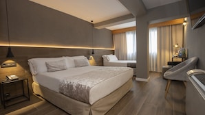 A modern hotel room with a large bed, bedside tables, a chair, and a desk with a lamp. - Yomo Eureka (Escaldes-Engordany)