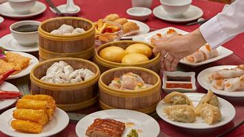 A table with various dishes including dumplings, fried items, and a plate of sliced meat, suggesting a meal setting.