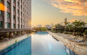 Una piscina al aire libre, tumbonas