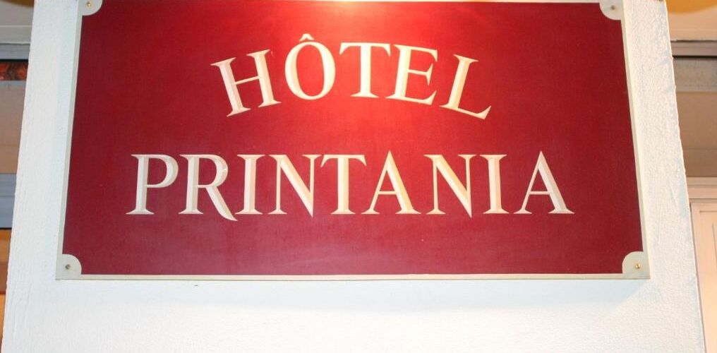 Un letrero con el texto 'Hôtel Printania' sobre un fondo rojo.