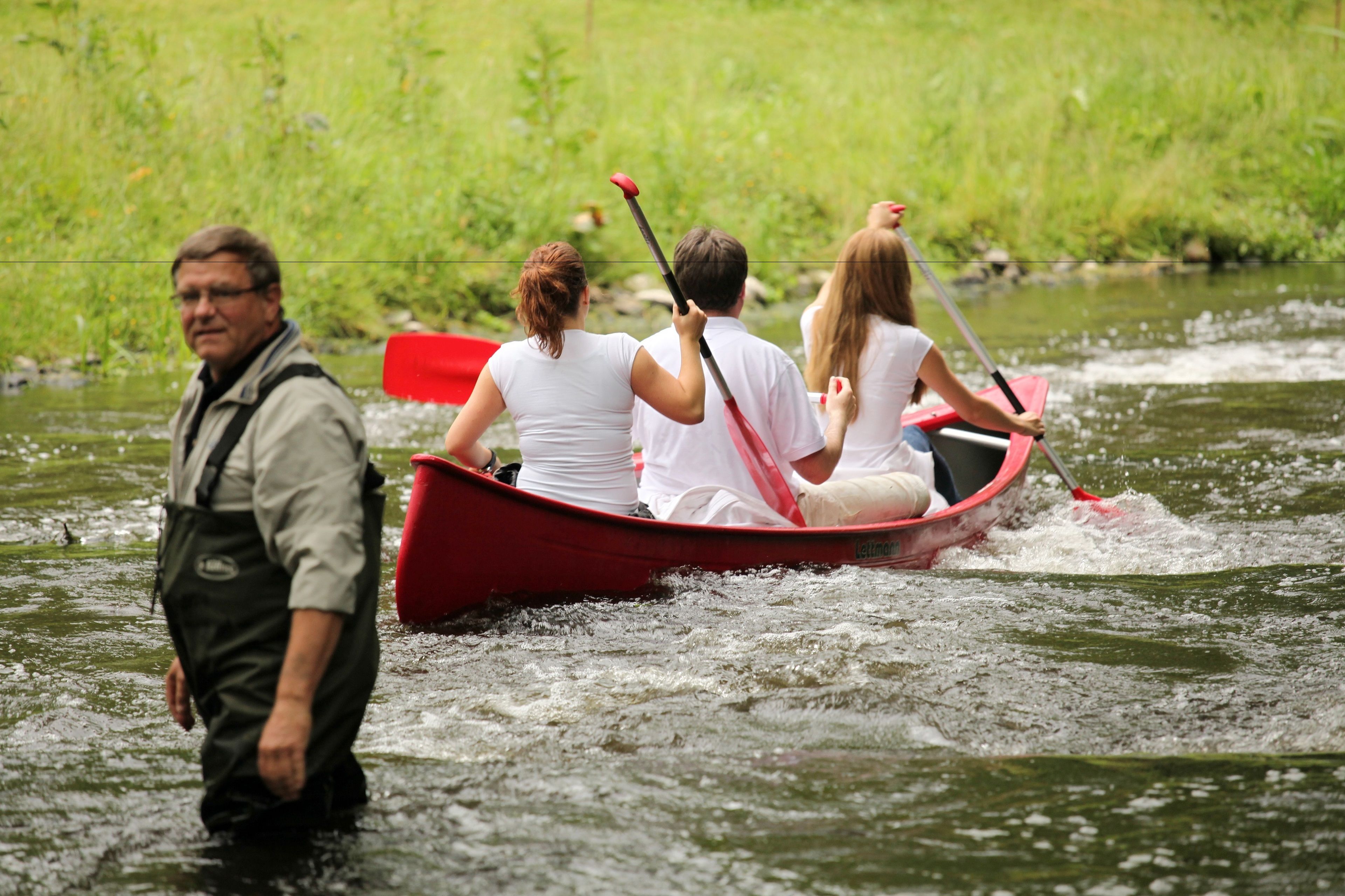 Un grupo de personas en un canoa roja sobre un río.