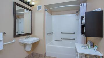 Une salle de bain équipée d’un lavabo, d’un miroir, d’une douche et d’un porte-serviettes.