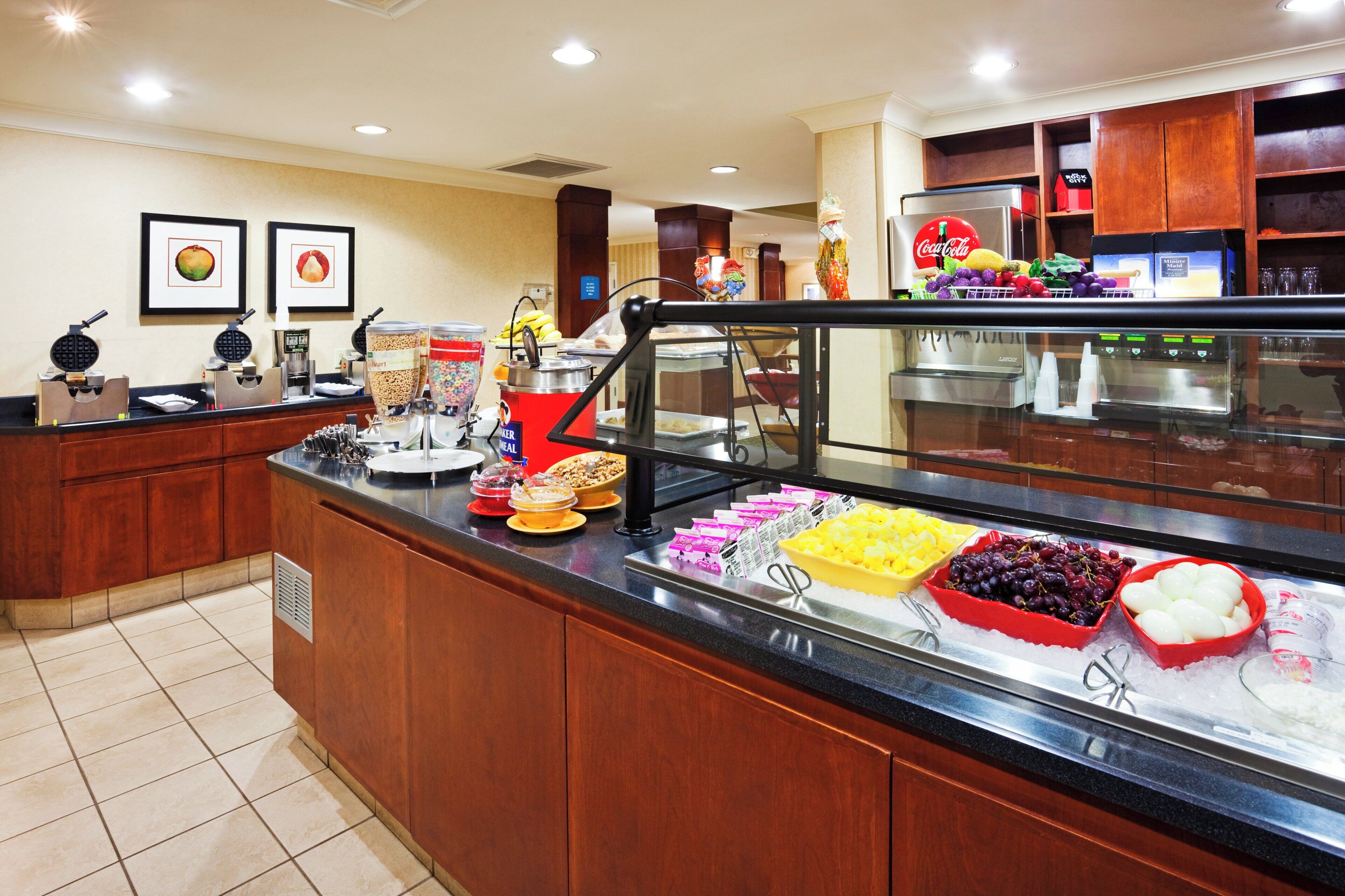 Un espace buffet proposant une variété de plats, un coin café et un réfrigérateur rempli de boissons.