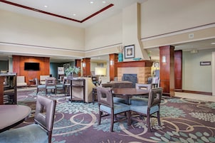 A hotel lobby with a fireplace, seating area, and a sign for the pantry.