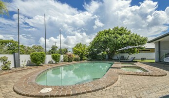 Una piscina al aire libre, tumbonas