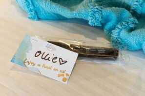 A package of dog treats with a tag that reads "Olive" and "Enjoy a treat on us!"