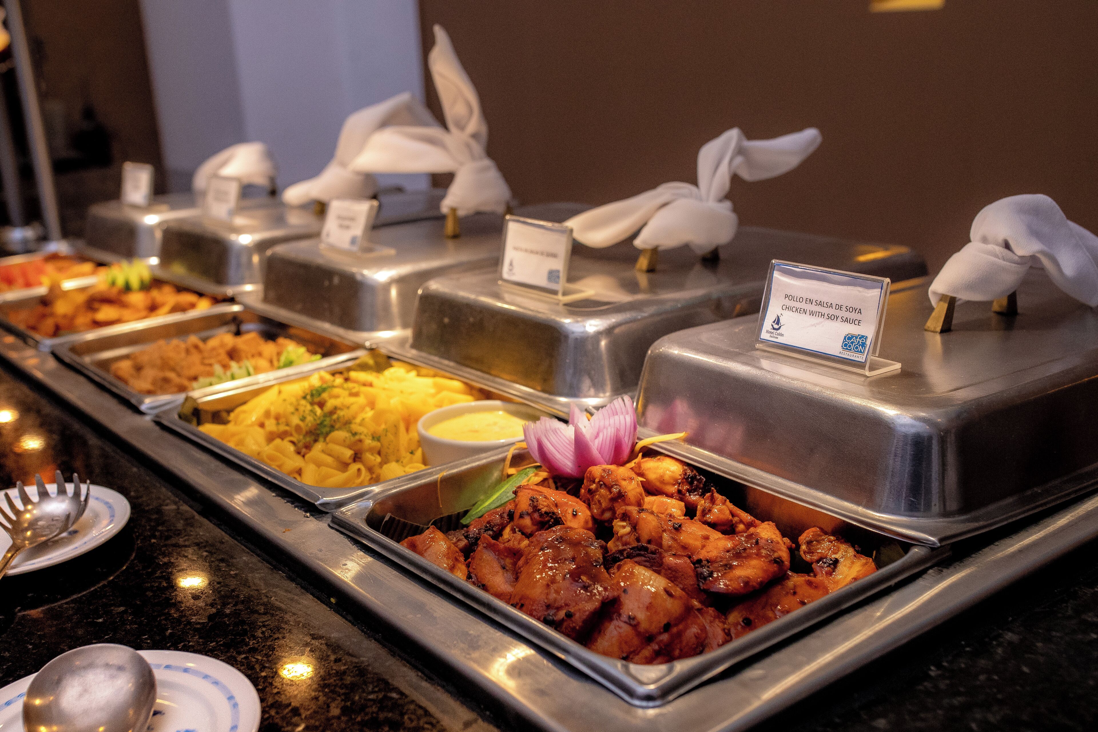 A buffet with various dishes including chicken and pasta.